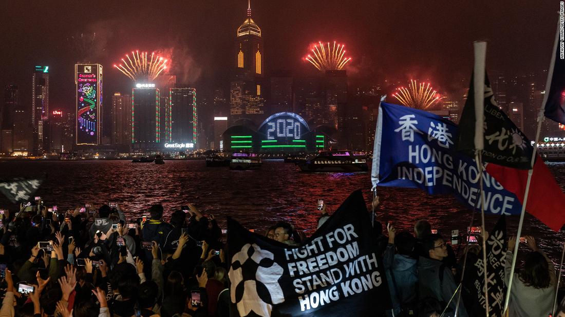 Pro-democracy supporters wave flags and shout slogans during a countdown party in the Tsim Sha Tsui district in Hong Kong.