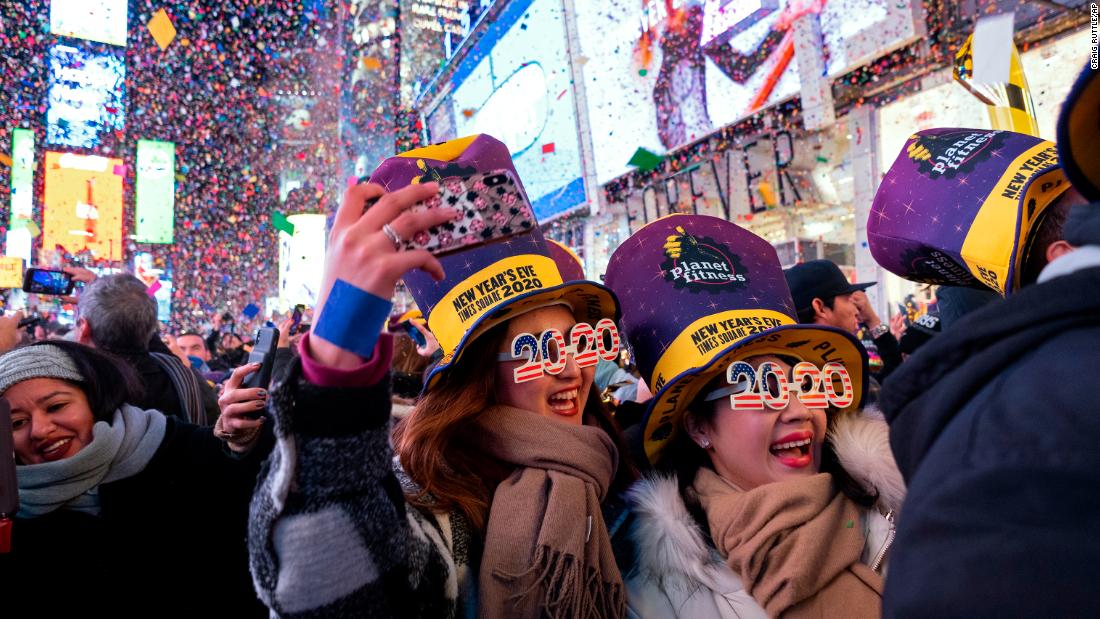 People celebrate as confetti falls in New York&#39;s Times Square.