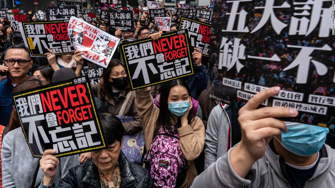 Pro-democracy supporters hold placards as they take part in a New Year's Day rally on Wednesday, January 1 in Hong Kong.
