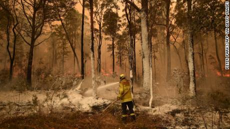 A firefighter sprays foam retardant ahead of a fire front in the New South Wales town of Jerrawangala on January 1, 2020.