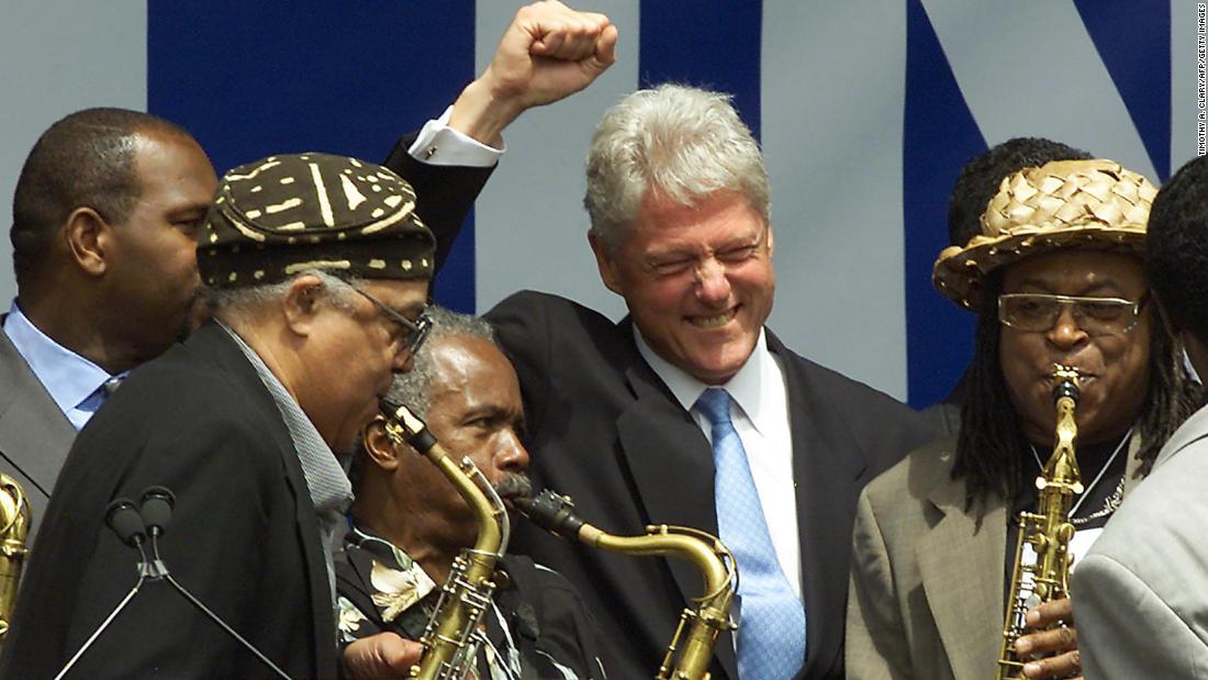 Clinton cheers a group of saxophone players at a rally in New York in July 2001. Harlem residents were welcoming Clinton, who was moving into his new post-presidential office.
