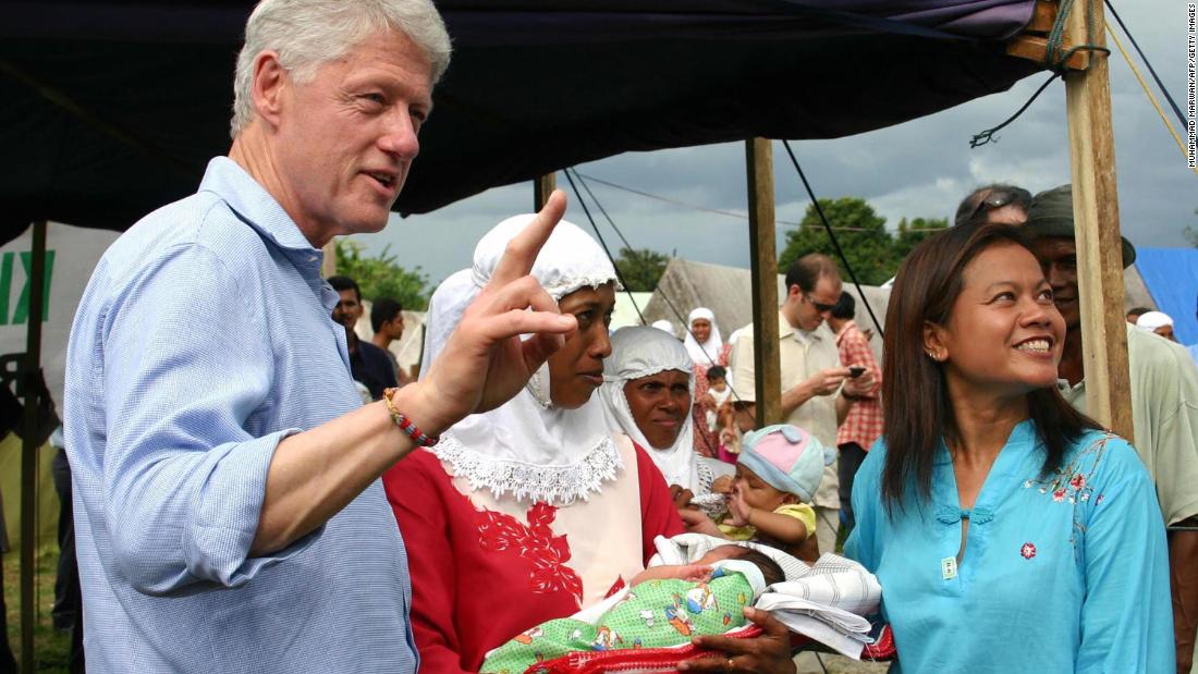 Clinton gestures as he explains to journalists that the baby being held here was born just two days earlier at a refugee camp in Jantho, Indonesia, in May 2005. Clinton was visiting ground zero of the tsunami disaster.
