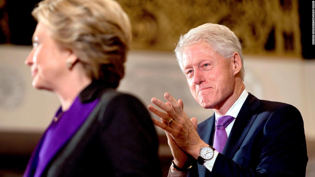 Clinton listens to his wife speak to supporters after her election defeat in 2016.