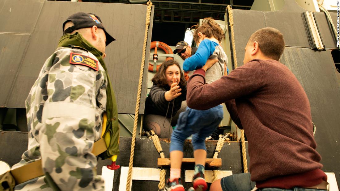 Evacuees board the Royal Australian Navy&#39;s MV Sycamore on January 3 in Mallacoota, Victoria, Australia. Navy ships plucked hundreds of people from beaches and tens of thousands were urged to flee before hot weather and strong winds in the forecast worsen Australia&#39;s already devastating wildfires. 