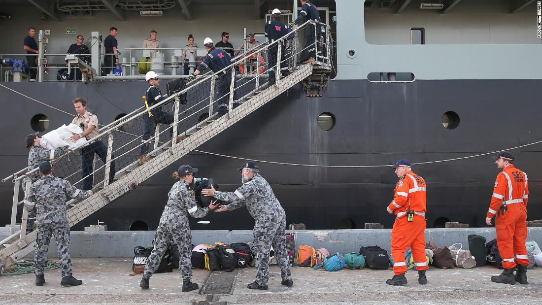 A Royal Australian Navy crew unload luggage as evacuees from Mallacoota arrive aboard the MV Sycamore on January 4 at the port of Hastings, Australia.