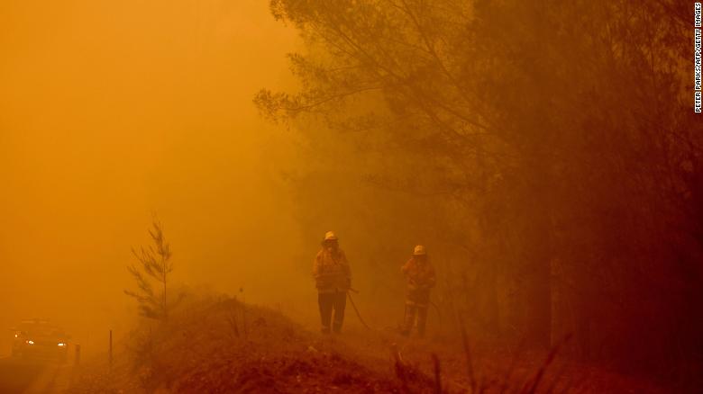 Firefighters tackle a bushfire in thick smoke in the town of Moruya, south of Batemans Bay, in the state of New South Wales on January 4.