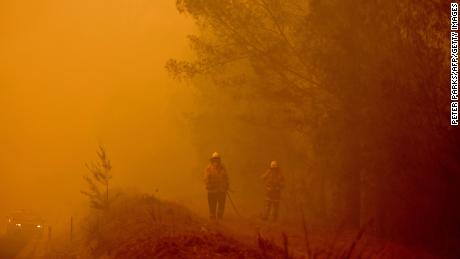 Firefighters tackle a bushfire in thick smoke in the town of Moruya, south of Batemans Bay, in the state of New South Wales on January 4.