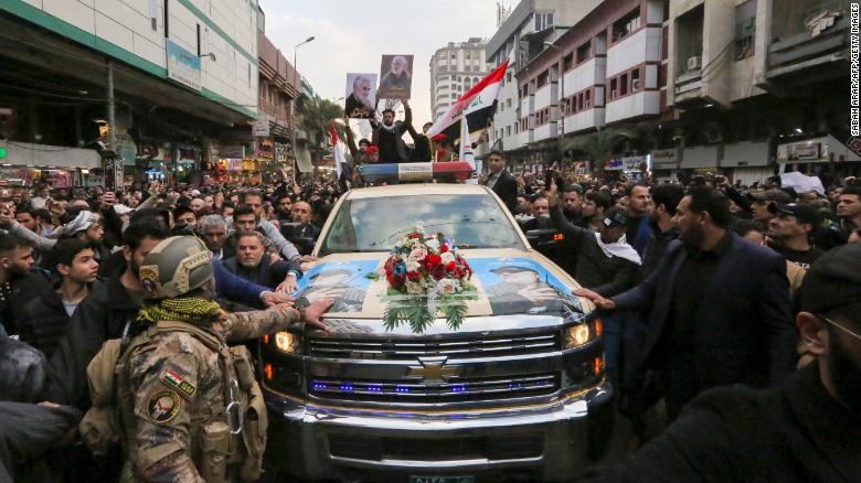 Mourners surround a car carrying  Qasem Soleimani's coffin on Saturday in Baghdad.