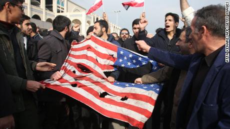  Iranians tear up a US flag during a demonstration in Tehran on January 3, 2020.