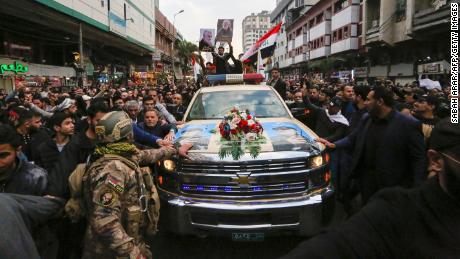 Iraqis mourn over a coffin during the funeral procession of Iraqi paramilitary chief Abu Mahdi al-Muhandis and Iranian military commander Qasem Soleimani, and eight others, in Kadhimiya, a Shiite pilgrimage district of Baghdad, on January 4, 2020. - Thousands of Iraqis chanting Death to America joined the funeral procession Saturday for Iranian commander Qassem Soleimani and Iraqi paramilitary chief Abu Mahdi al-Muhandis, both killed in a US air strike. The cortege set off around Kadhimiya, a Shiite pilgrimage district of Baghdad, before heading to the Green Zone government and diplomatic district where a state funeral was to be held attended by top dignitaries. In all, 10 people -- five Iraqis and five Iranians -- were killed in Friday morning's US strike on their motorcade just outside Baghdad airport. (Photo by SABAH ARAR / AFP) (Photo by SABAH ARAR/AFP via Getty Images)