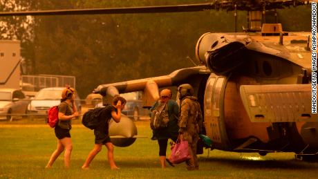 An Australian army soldier helps people evacuate onto a Black Hawk helicopter in Omeo, Victoria on January 5, 2020.