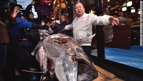 Kiyoshi Kimura (R), President of Kiyomura Corp., the Tokyo-based operator of sushi restaurant chain Sushizanmai, displays a 276-kilogram bluefin tuna that fetched 193.2 million yen (1.8 million USD) at his main restaurant in Tokyo on January 5, 2020 after the New Year&#39;s auction at Toyosu fish market.