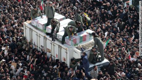 Iranian revolutionary guards surround the coffins of Soleimani and other victims during the procession.