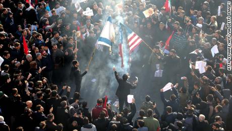 Iranians set a US and an Israeli flag on fire during Soleimani&#39;s funeral procession.