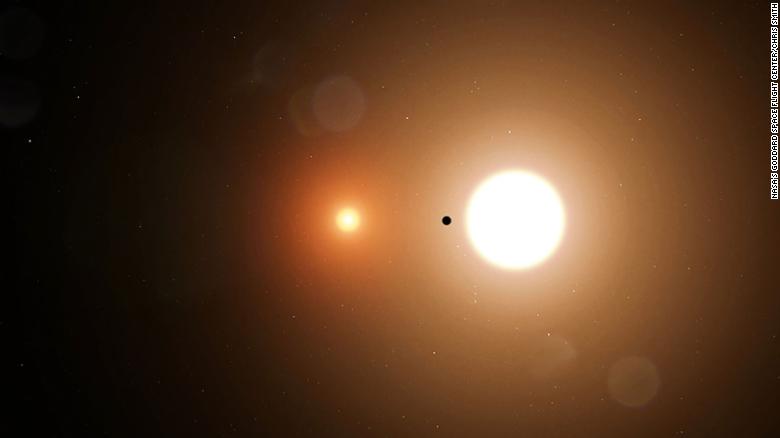 TOI 1338 b είναι silhouetted από τα αστέρια υποδοχής του.  Το TESS ανιχνεύει μόνο τις μεταφορές από το μεγαλύτερο αστέρι