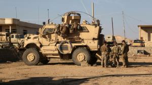 In this Thursday, Feb. 23, 2017 photo, U.S. Army soldiers stand outside their armored vehicle on a joint base with Iraqi army south of Mosul, Iraq. As Iraqi forces push into western Mosul coalition troops are closer to frontline fighting than ever before. Coalition forces have moved their bases closer to the front, relaxed their rules of engagement and during the push on Mosul airport coalition advisors were embedded with forward Iraqi rapid response and special forces units. Coalition officials say the change is helping speed up Iraqi military gains, but it marks a steady escalation of U.S. involvement in Iraq that could undermine the sustainability of Iraq's territorial victories. (AP Photo/ Khalid Mohammed)