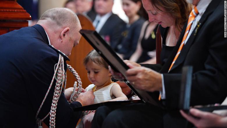 Charlotte O&#39;Dwyer  receives her fathers service medal from RFS Commissioner Shane Fitzsimmons.