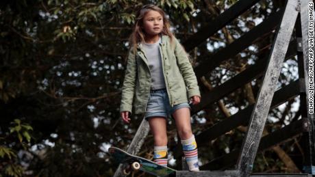 Brown stands with her skateboard before dropping in on the halfpipe.