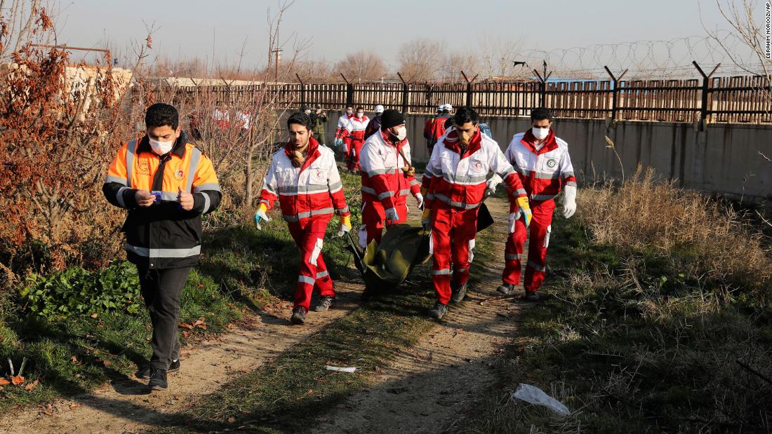 Crews transport a victim's body from the scene.