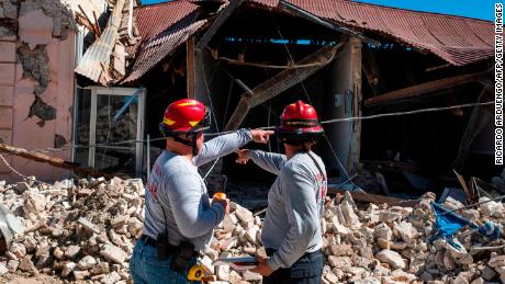 Firefighters survey a collapsed building after an earthquake hit Guanica on January 7.