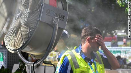A man cools down in front of a mist fan for relief from the hot weather in Melbourne, Australia. 