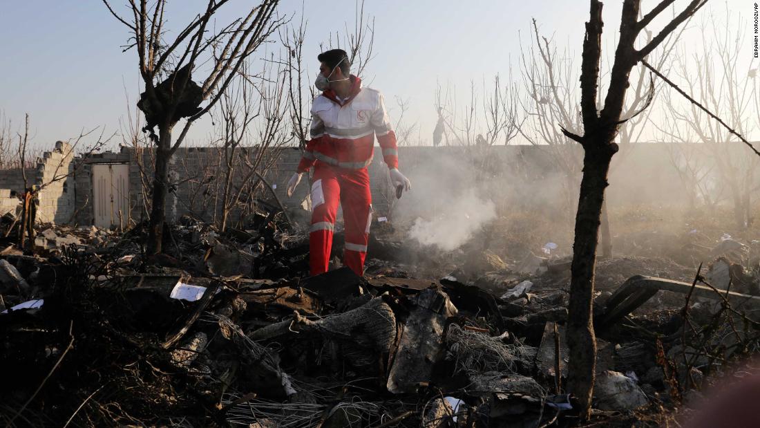 A rescuer stands amid the crash debris.