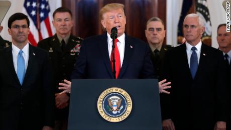 President Donald Trump addresses the nation from the White House on the ballistic missile strike that Iran launched against Iraqi air bases housing U.S. troops, Wednesday, Jan. 8, 2020, in Washington, as Vice President Mike Pence and others looks on.