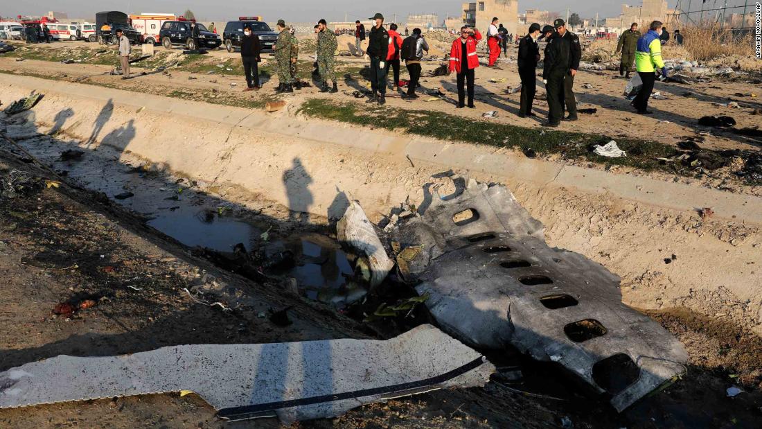 Debris from the plane is seen as authorities work at the site of the crash.