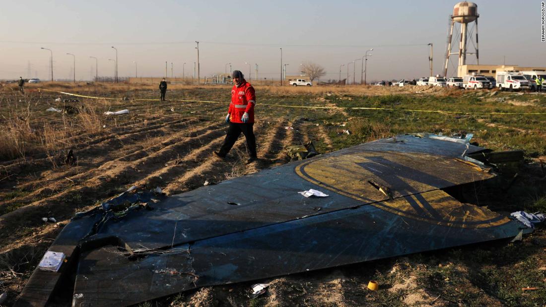 An emergency worker passes part of the destroyed plane.