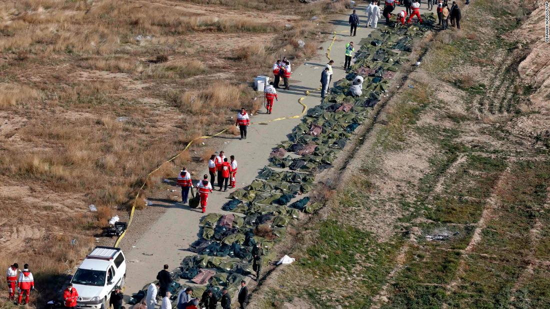 Bodies are recovered by emergency crews at the scene of a plane crash in Iran on Wednesday, January 8.