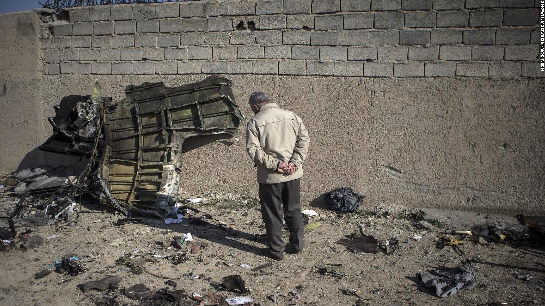 A man observes a piece of the wreckage.