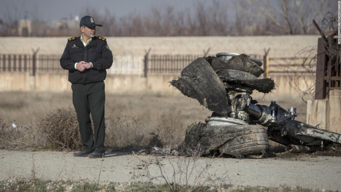 An official stands near a piece of plane wreckage.