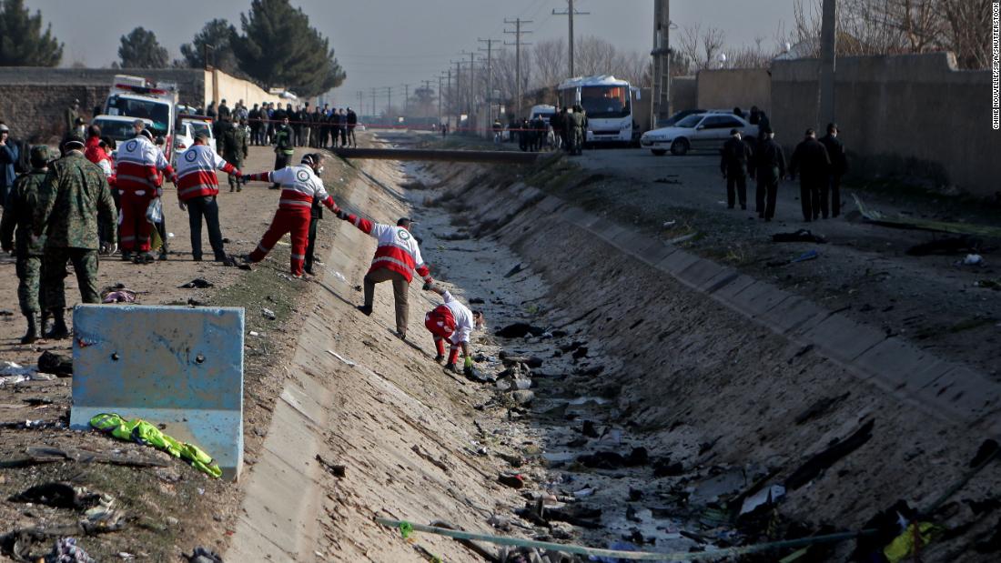 Rescuers work to recover debris from the plane.