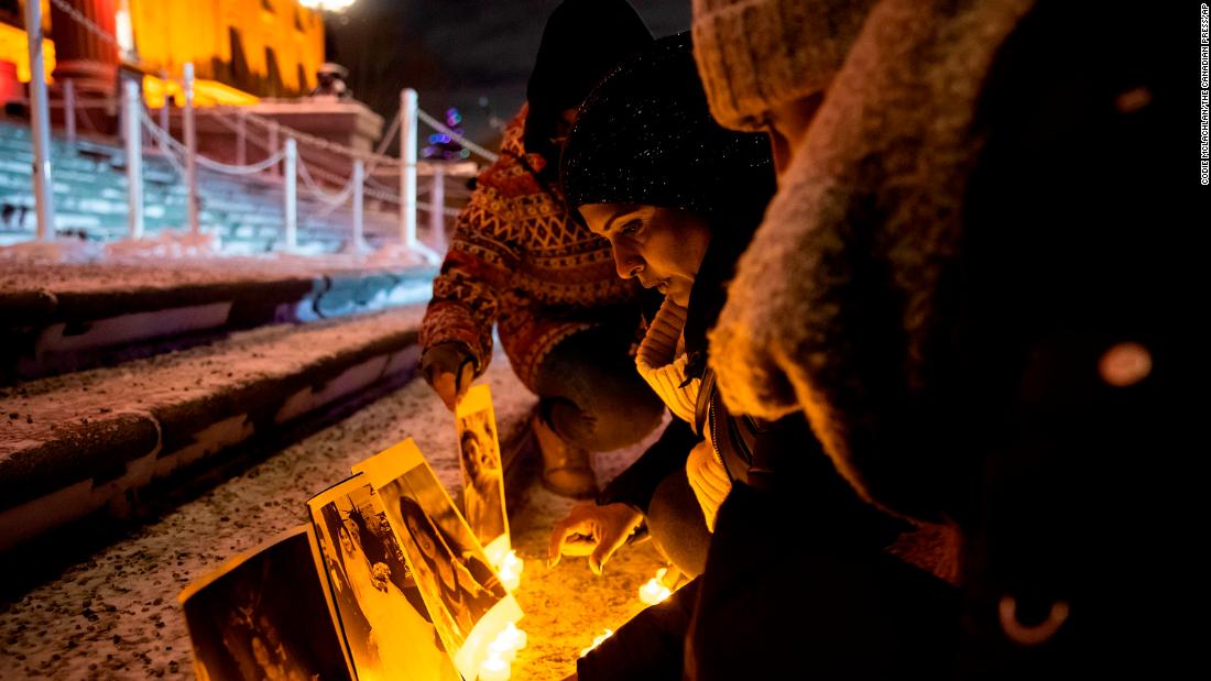 Mourners place candles and photographs outside the Alberta Legislature Building during a vigil in Edmonton, Alberta.