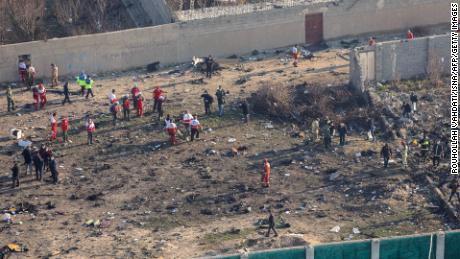 Rescue teams gather where a plane crashed in Tehran early January 8, killing all 176 people aboard.