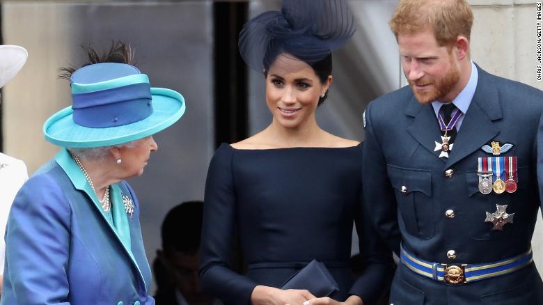 Queen Elizabeth II talks with the Duke and Duchess of Sussex during an RAF flypast of Buckingham Palace in 2018. 