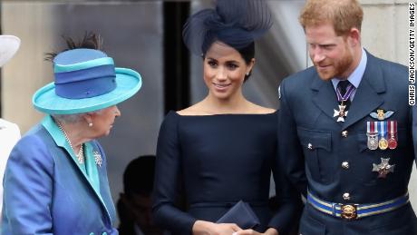 Queen Elizabeth II talks with the Duke and Duchess of Sussex during an RAF flypast of Buckingham Palace in 2018. 