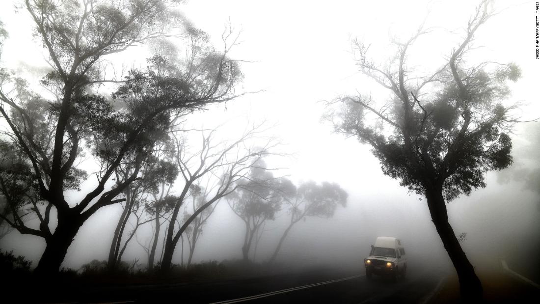 A vehicle makes its way through thick fog mixed with bushfire smoke in the Ruined Castle area of the Blue Mountains on January 11.