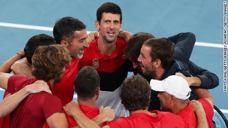 Novak Djokovic celebrates with his Serbia teammates after sending the team into the ATP Tour Cup finals.