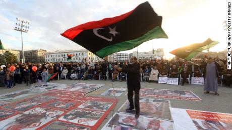 Demonstrators wave flags and step on posters of some world leaders as they take part in a rally against eastern Libyan strongman Khalifa Haftar, and in support of the UN-recognised government of national accord (GNA) in Martyrs&#39; Square in the GNA-held capital Tripoli on January 10, 2020. 