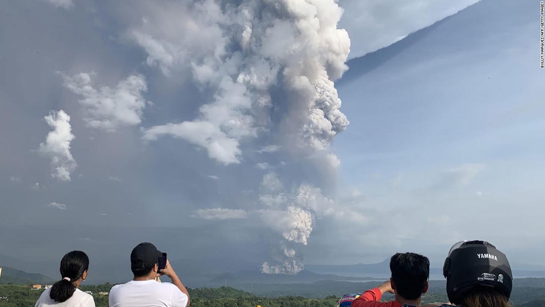 People take photos of the eruption on January 12.