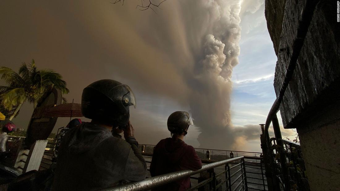 People in Tagaytay watch plumes of smoke and ash rise from the volcano on January 12.