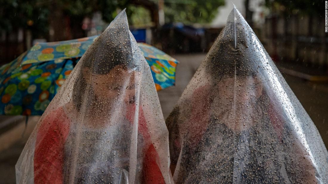 Talisay residents use plastic bags to shield themselves from ash mixed with rainwater.