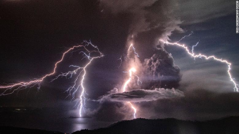 Lightning strikes as a column of ash surrounds the crater of Taal Volcano as it erupts on January 12, 2020.