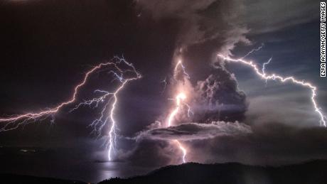 Lightning strikes as a column of ash surrounds the crater of Taal Volcano as it erupts on January 12, 2020.