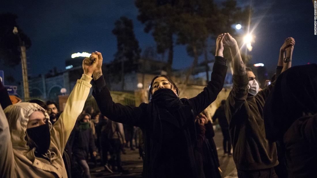 Iranians held hands during a demonstration in front of Tehran's Amir Kabir University on January 11, 2020. 