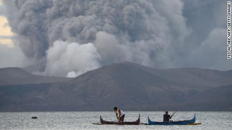 Residents living along Taal lake catch fish as Taal volcano erupts in Tanauan town.