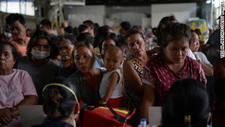 Evacuees from towns affected by the eruption of Taal volcano queue up to have their children checked by medical personnel at an evacuation center in Tanauan town, Batangas province.