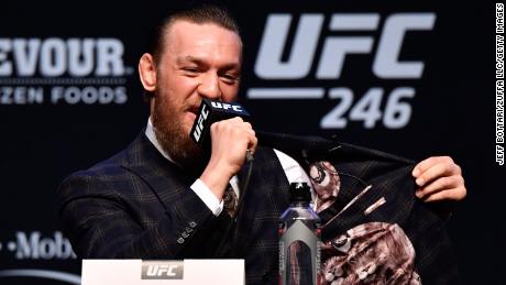 McGregor flashes the inside of his jacket during the UFC 246 press conference.