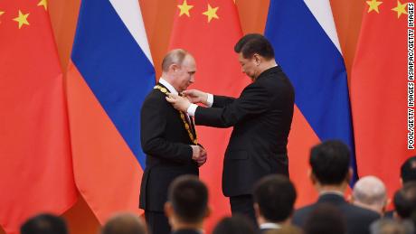 Chinese President Xi Jinping congratulates Russian President Vladimir Putin after presenting him with the Friendship Medal in the Great Hall of the People on June 8, 2018 in Beijing, China. 